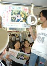 吉川友梨ちゃんの情報提供を訴える手作りポスターを電車につるす児童ら（和歌山県橋本市のＪＲ橋本駅で）